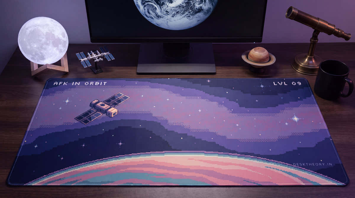 AFK in Orbit pixel art desk mat on a desk at night